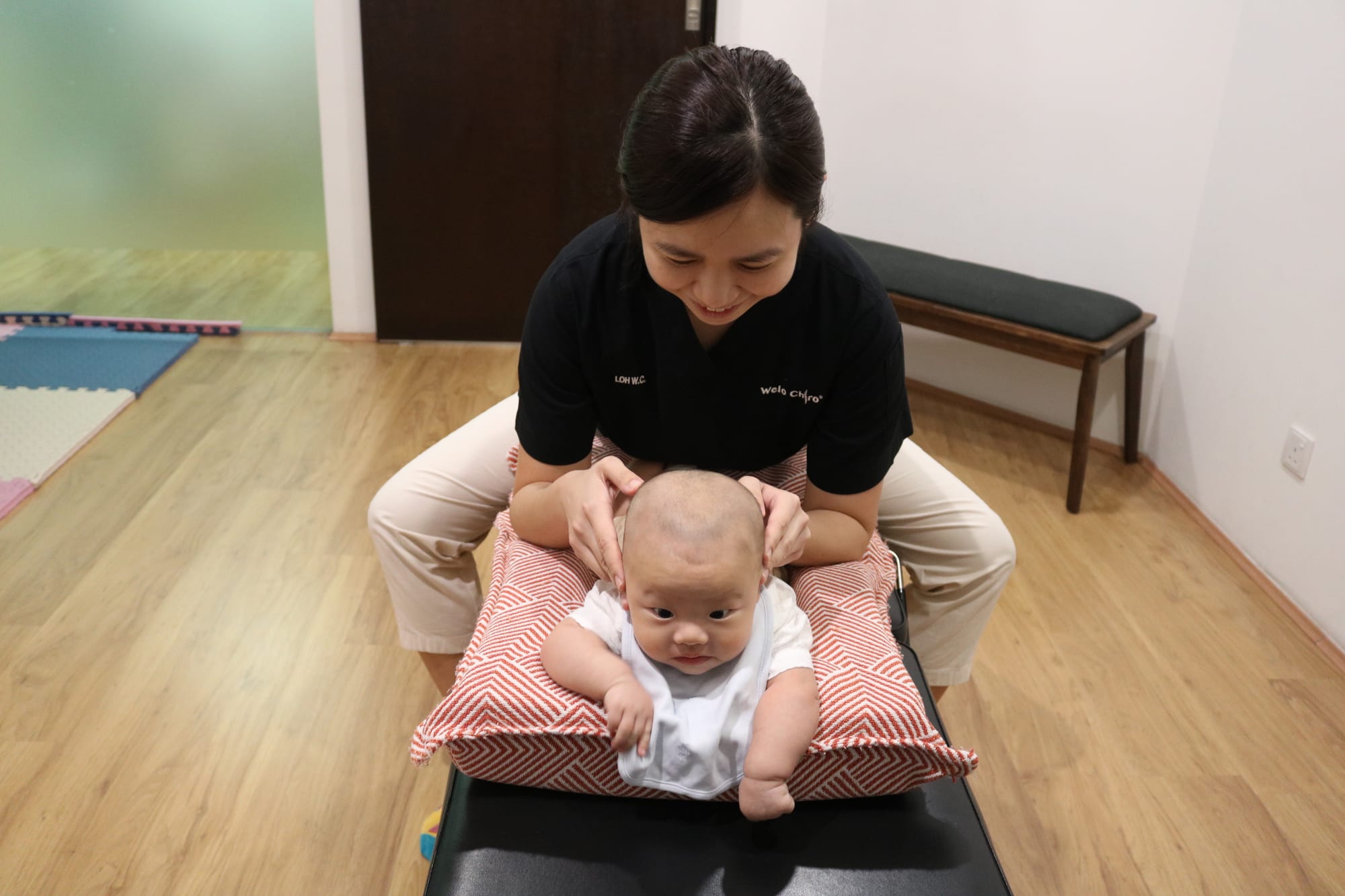 A Welo chiropractor treating an infant on a cushioned table